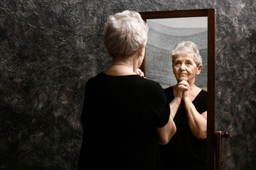 Senior woman looking in mirror