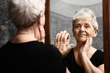 Senior woman looking in mirror