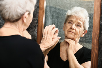 Senior woman looking in mirror