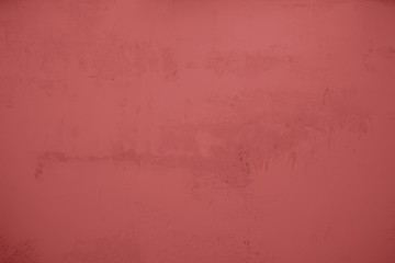 Pastellrote Betonwand mit verputzten Strukturen. Roter Hintergrund im Industrial Design. Strukturierte Steinwand als Textur und gestalterisches Element für Kunst und Kollagen. 
