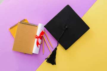 Mortar board, diploma and stationery on color background. Concept of high school graduation