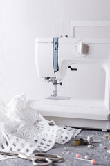 Vertical shot of tailor`s workplace.Sewing machine,white fabric,scissors and different accessories for sewing clothes