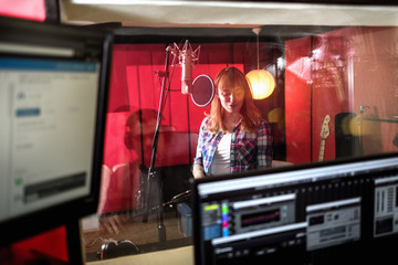 Female singer during vocal recording at music studio