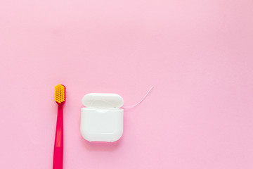 Dental hygiene - tooth brushes, dental floss flat lay, top view, copy space, pink background