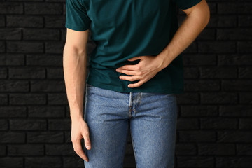 Man with urologic disease on dark background