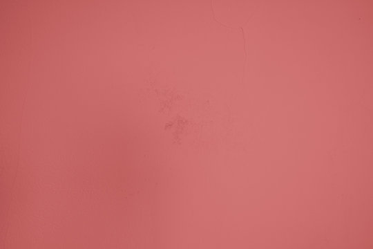 Pastellrote Betonwand mit verputzten Strukturen. Roter Hintergrund im Industrial Design. Strukturierte Steinwand als Textur und gestalterisches Element f&uuml;r Kunst und Kollagen. 