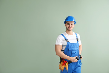 Male electrician on color background