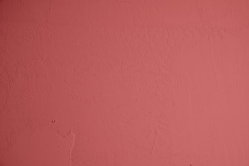 Pastellrote Betonwand mit verputzten Strukturen. Roter Hintergrund im Industrial Design. Strukturierte Steinwand als Textur und gestalterisches Element für Kunst und Kollagen. Hintergund im Hochformat