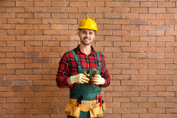 Male electrician near brick wall