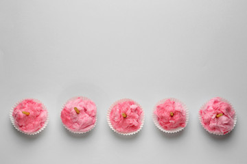 Tasty cotton candy with candles on grey background