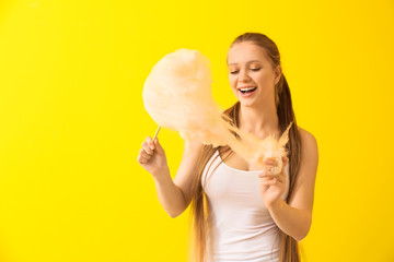 Beautiful woman with cotton candy on color background