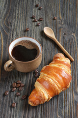 Delicious croissant and cup of coffee