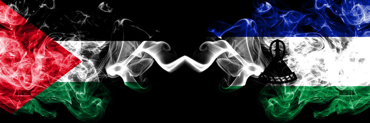 Palestine vs Lesotho smoky mystic flags placed side by side. Thick colored silky smokes flag of Palestinians and Lesotho