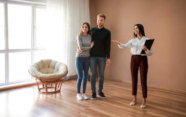 Real estate agent showing young couple a new house