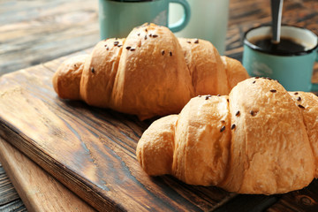 Tasty croissants on wooden board