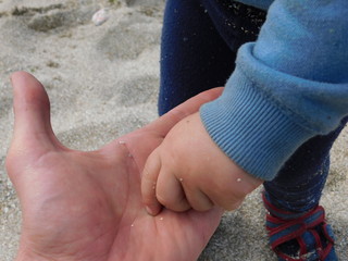  parent and child on the beach. hands macro