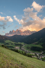 Small Italian mountain town of St. Magdalena in Val di Funes at sunset