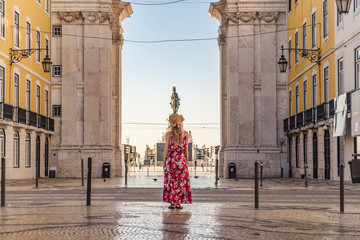 Young blonde tourist woman walking on the Rua Augusta street in Lisbon city and exploring old...