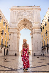 Young blonde tourist woman walking on the Rua Augusta street in Lisbon city and exploring old architecture, Portugal - obrazy, fototapety, plakaty