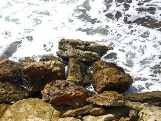 Picturesque view with stones and surf waves on the wild Crimean coast of Black sea in the area of Chersonesos cape. The peninsula of Crimea. Top view of the sea shore with stones and surf waves 