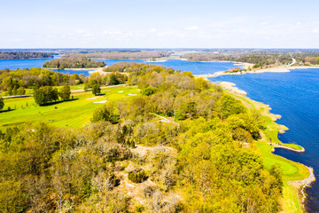 Golf course on an island surrounded by forest and water on a sunny spring day. Location Almo in Blekinge archipelago, Sweden.