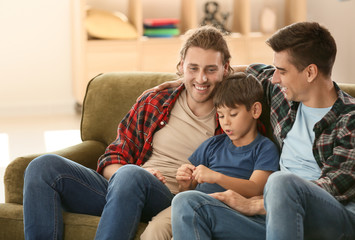 Obraz premium Happy gay couple with adopted child at home