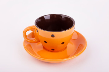 Orange cup in peas on saucer, isolate