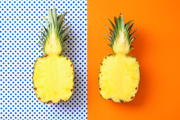Halves of ripe pineapple on color background
