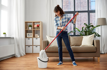 people, housework and housekeeping concept - happy asian woman with mop and bucket cleaning floor...