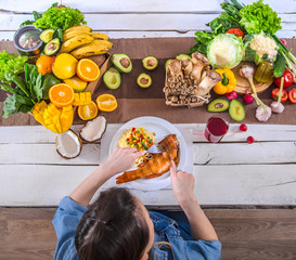 The woman at the dinner table with organic food , the view from the top.