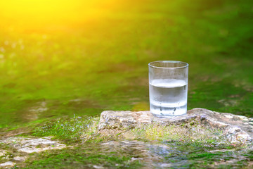 The glass of cool fresh water on nature background