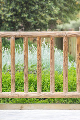 Obraz premium Wooden fence and some flowers in a home garden. Floral background and empty copy space for Editor's text.