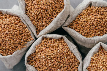 Small linen bags filled with raw buckwheat for your healthy eating. Agriculture and farming. Uncooked buckwheat. Dietary product