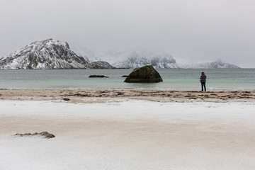 Asian women stand at the sea and the snow-capped mountains on the beach On a day of thick fog and...