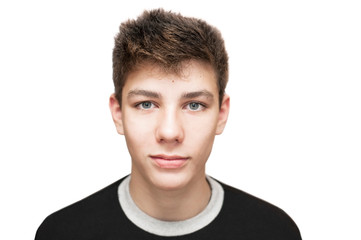 A handsome young man adolescents smiles ironically on a white background. Isolated