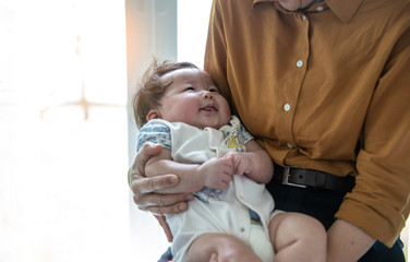 A little baby girl  smiling and looking at Grandmother  in home