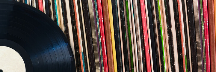 Vinyl record in front of a collection of albums, vintage music concept