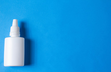 nasal drops bottle isolated on blue background