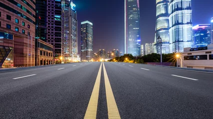 Gordijnen Shanghai modern commercial office buildings and empty asphalt highway at night © ABCDstock