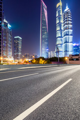 Fototapeta na wymiar Shanghai modern commercial office buildings and empty asphalt highway at night