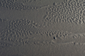 Black volcanic sand waves abstract background texture with copyspace. Black beaches of Iceland.