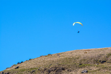 Fototapeta na wymiar An adventurer glides through the sky over the Yorkshire Moorlands on a clear sunny day
