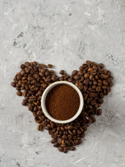 A Cup of freshly ground coffee on the table with coffee beans in the shape of a heart