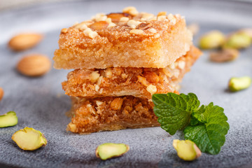 traditional arabic sweets in gray ceramic plate on a gray concrete background. close up.