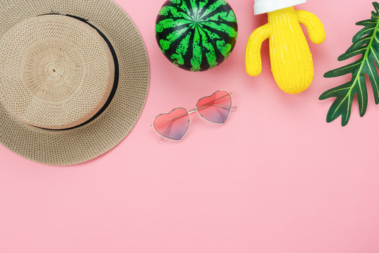 Table top view accessory of clothing women  plan to travel in summer holiday background concept.Cactus with many essential items sunglasses & watermelon on modern rustic pink paper.Space for design.