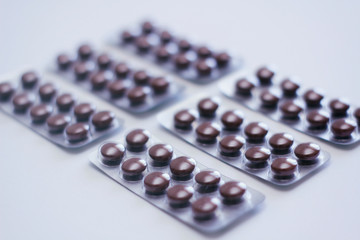 Set of plastic blisters with brown round pills. On white background.