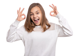 Beautiful Teen Girl Student making Ok Gesture. Portrait of caucasian Smiling Teenager isolated on white background. Happy child looking at camera.