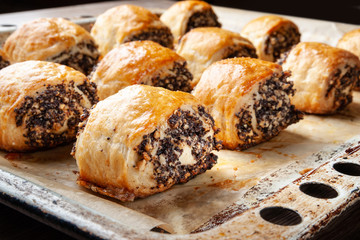 Crispy freshly baked cookies with poppy seeds on a baking tray.
