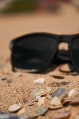 Sunglasses on sandy beach in summer - vintage color styles