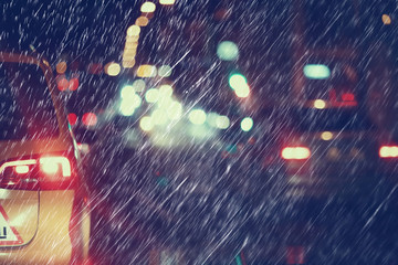 blurred background autumn auto rain on the road / night lights and raindrops in the autumn traffic jam on the road, urban style traffic
